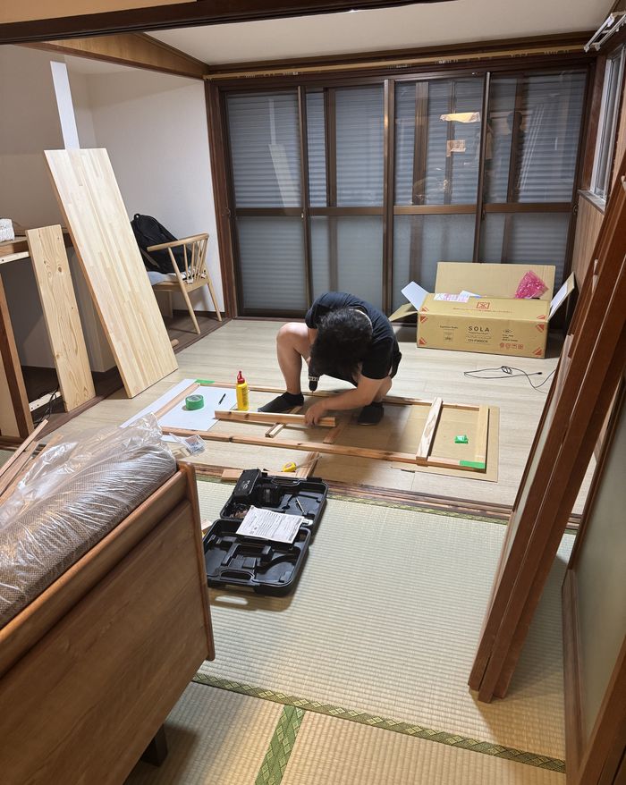 畳の部屋で木の枠を組み立てている様子